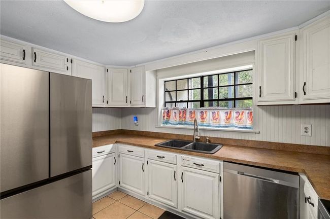 Kitchen with white cabinets and stainless steel appliances. | Image 4