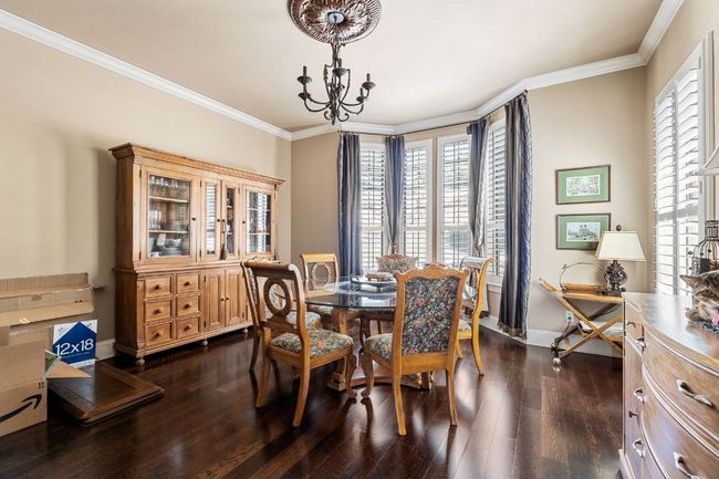 Dining area with ornamental molding, a chandelier, and hardwood floors | Image 19