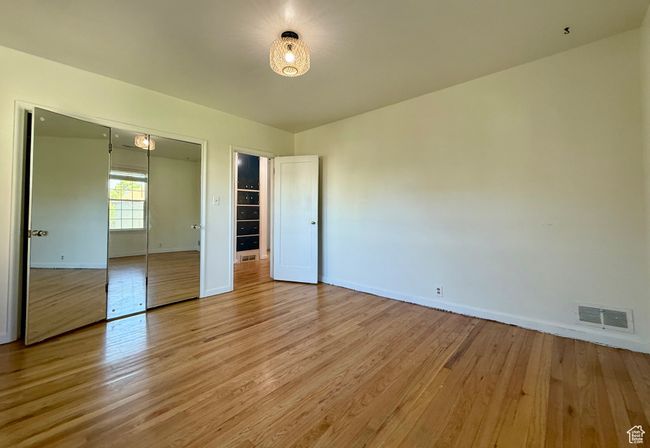 Unfurnished bedroom with light wood-style floors, baseboards, and a closet | Image 20