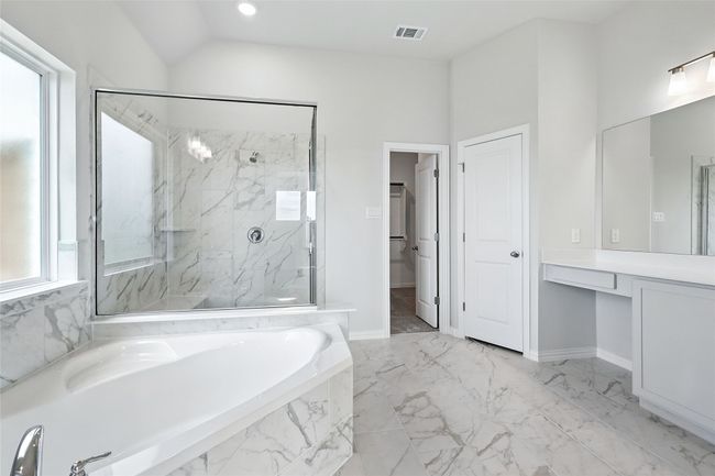 Bathroom featuring a garden tub, vanity, a marble finish shower, and marble finish floors | Image 18