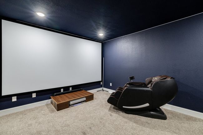 Carpeted cinema room with a textured ceiling | Image 17