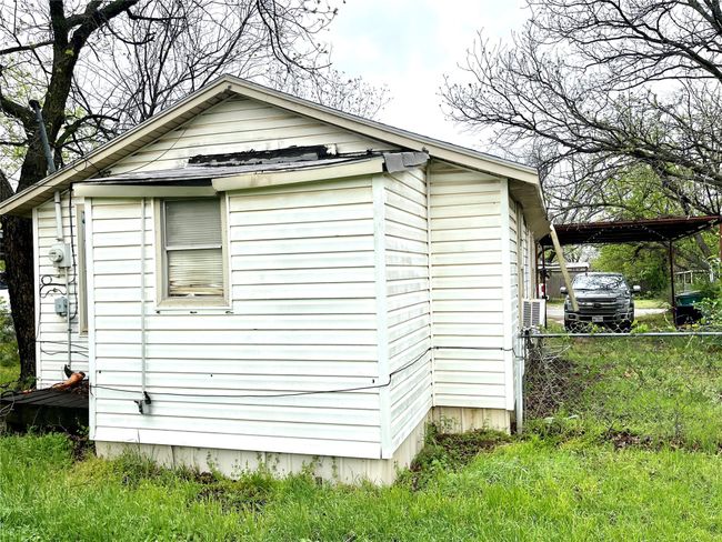View of side of home featuring a detached carport and an outdoor structure | Image 18