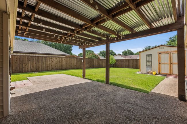 Fenced backyard with a patio and a storage unit | Image 28