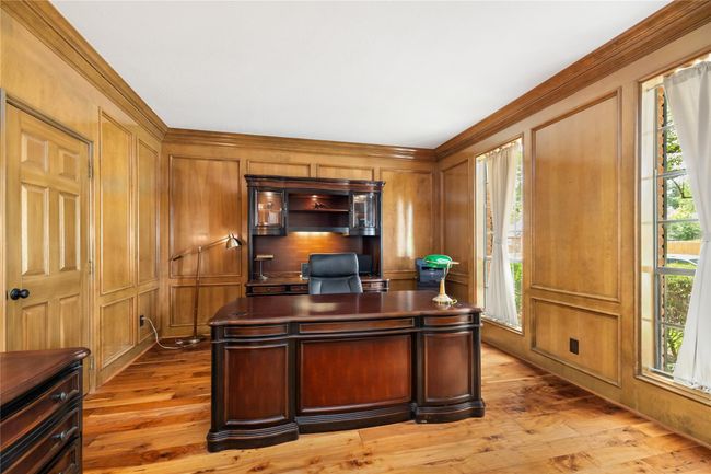 Lined with rich wood tones and bathed in natural light, this private office offers a quiet and refined space to work, create, or study—complete with French doors for added privacy and elegance. | Image 9