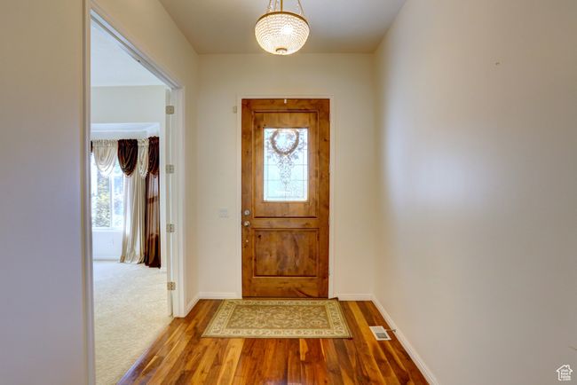 Doorway to outside with visible vents, baseboards, and wood finished floors | Image 6