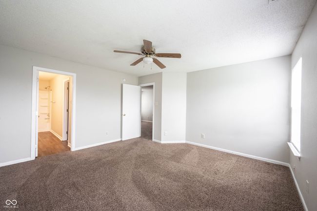 unfurnished bedroom with baseboards, multiple windows, and carpet | Image 32