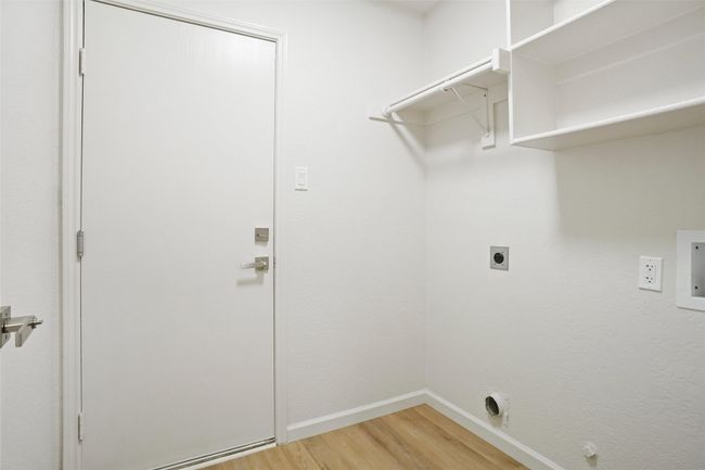 Laundry area featuring electric dryer hookup, light wood-style floors, and baseboards | Image 22