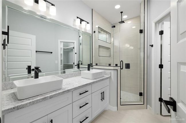 Full bath featuring a shower stall, double vanity, tile patterned flooring, and recessed lighting | Image 9