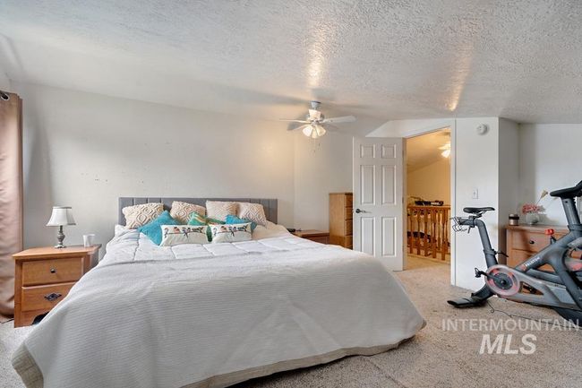 Carpeted bedroom featuring a textured ceiling and a ceiling fan | Image 22