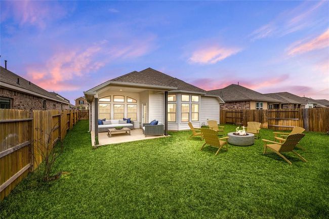 Spacious backyard with a covered patio lounge and cozy fire pit area—perfect for outdoor entertaining and relaxation. *Virtually Staged | Image 21