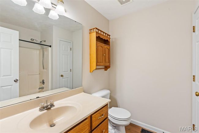 Full bathroom featuring toilet, vanity, shower / bathtub combination, wood finished floors, and baseboards | Image 22