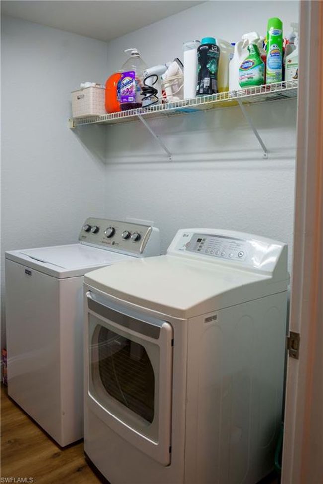 Laundry area with laundry area, separate washer and dryer, and wood finished floors | Image 25