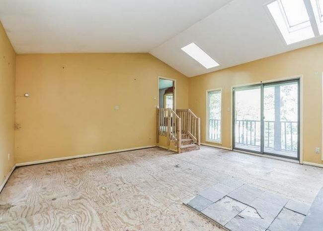 Unfurnished room with lofted ceiling with skylight | Image 8