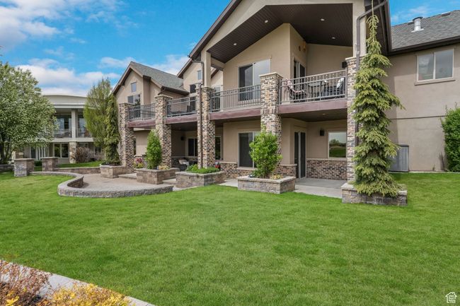 Rear view of house featuring a yard, a balcony, and lower patio. | Image 29