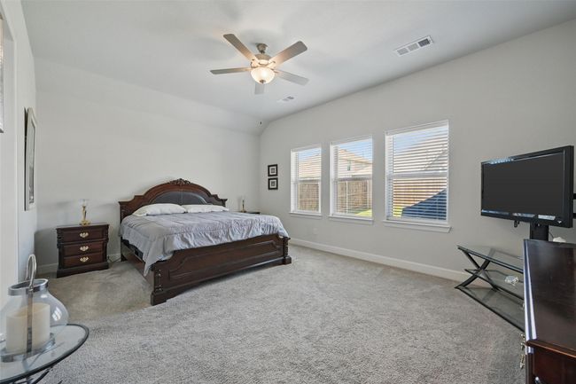 Bedroom with carpet flooring, baseboards, a ceiling fan, and vaulted ceiling | Image 12