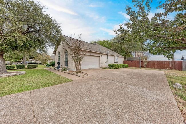 View of front of house with concrete driveway, an attached garage, brick siding, and roof with shingles | Image 4
