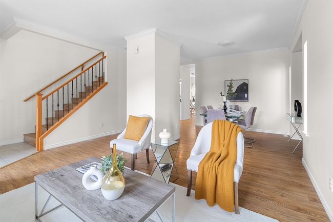 Living area with wood finished floors, stairs, crown molding, and baseboards | Image 6