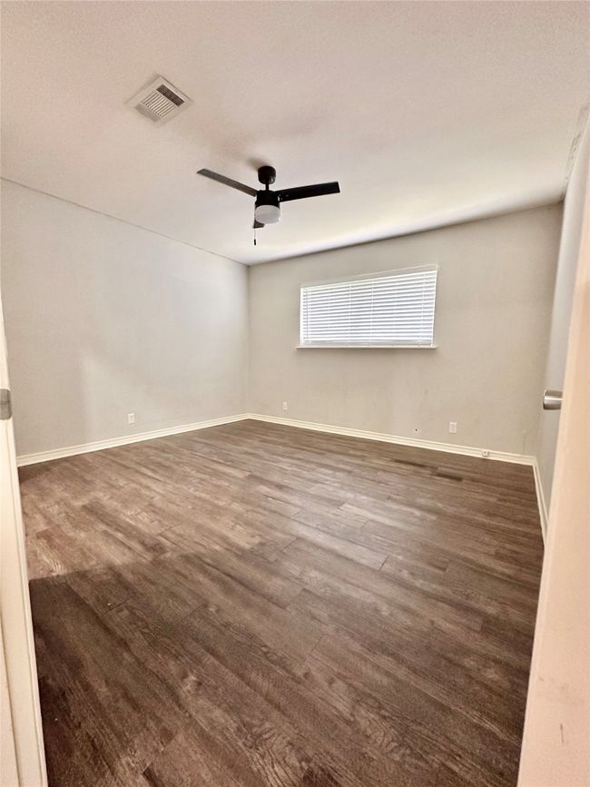 Spare room with ceiling fan and dark wood-style flooring | Image 23