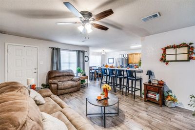 Unit 316 Living room featuring wood-style vinyl floors, a textured ceiling, and ceiling fan | Image 3