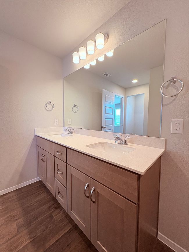 Bathroom with visible vents, wood finished floors, a sink, and double vanity | Image 34