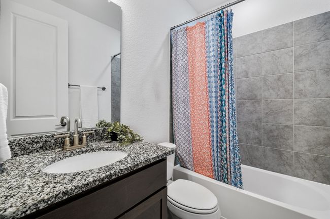 Full bathroom featuring vanity, shower / bath combination with curtain, and toilet | Image 14