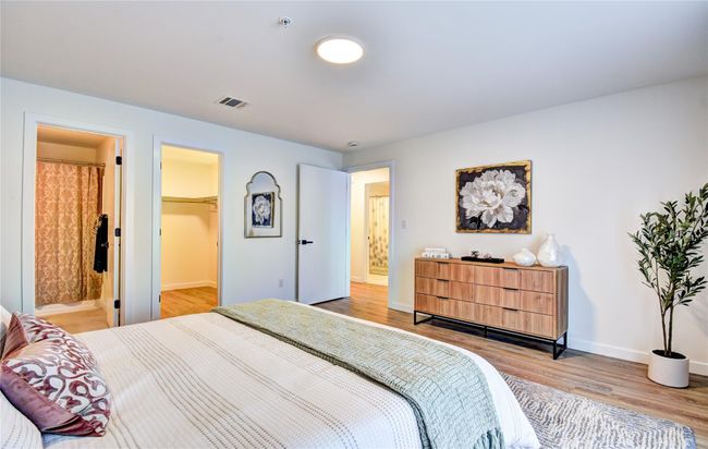 Bedroom featuring baseboards, visible vents, a spacious closet, light wood-type flooring, and connected bathroom | Image 15