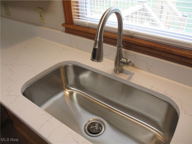 Details featuring light stone counters and a sink | Image 4