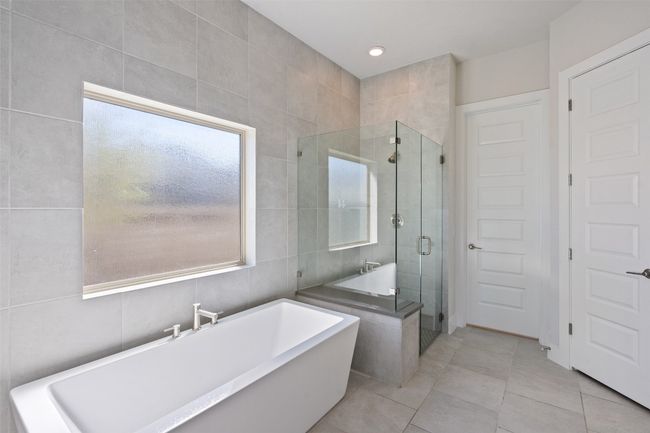 Full bath with a freestanding bath, a stall shower, tile walls, tile patterned floors, and recessed lighting | Image 21