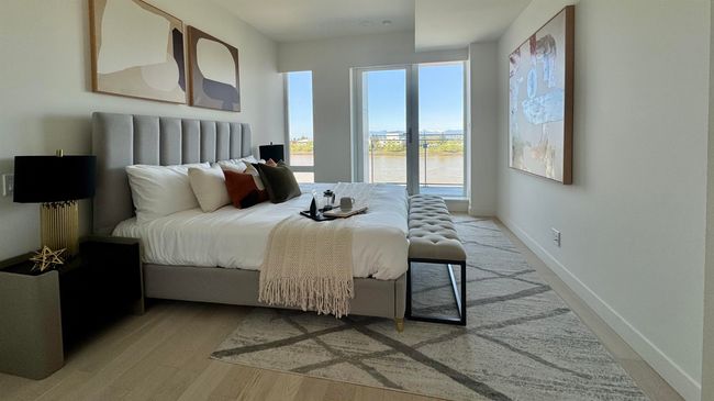 Bedroom featuring light wood-type flooring, baseboards, and a water view | Image 6