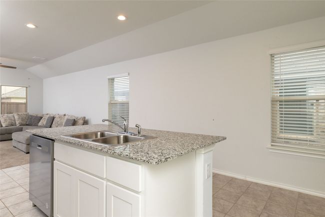 Kitchen featuring a sink, dishwasher, an island with sink, open floor plan, and vaulted ceiling | Image 13