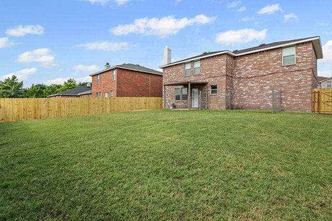 Rear view of property with brick siding, a fenced backyard, and a chimney | Image 22