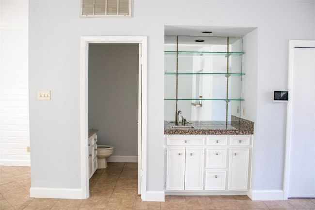 Bar featuring baseboards, indoor wet bar, visible vents, and a sink | Image 9