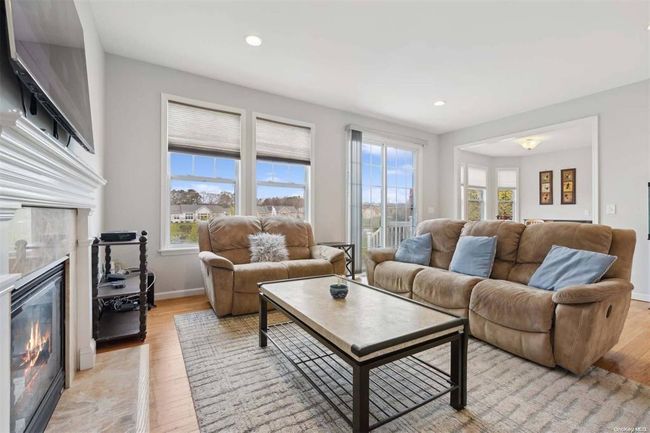 Living room featuring a tiled fireplace, light wood-style floors, recessed lighting, and baseboards | Image 8
