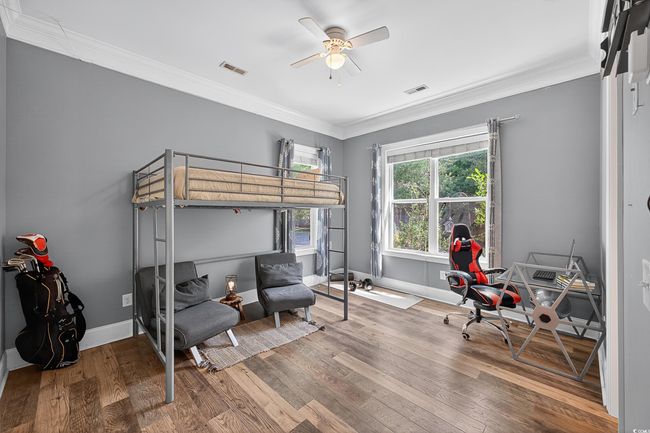 Bedroom featuring wood finished floors, crown molding, and a ceiling fan | Image 26