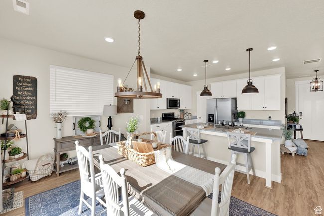 Dining area featuring light wood finished floors and recessed lighting | Image 8