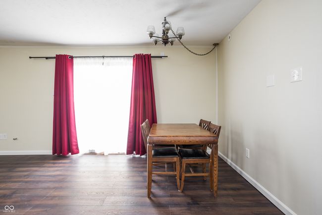 dining area with wood finished floors and a chandelier | Image 12
