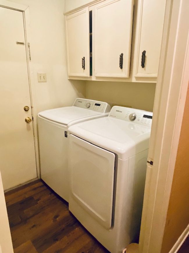 Laundry area with cabinet space, dark wood finished floors, and washing machine and clothes dryer | Image 15