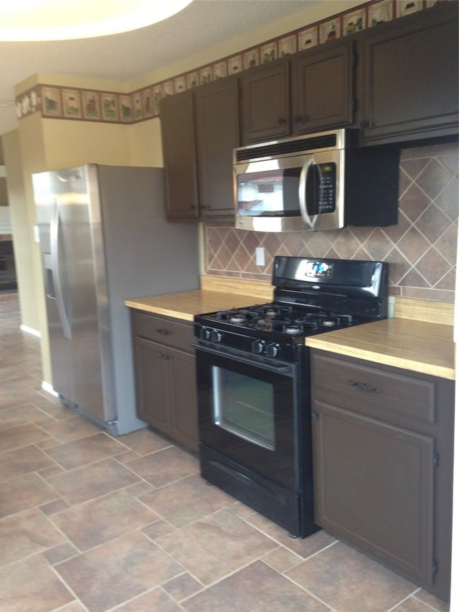 Kitchen with light countertops, backsplash, and range with gas stovetop | Image 6
