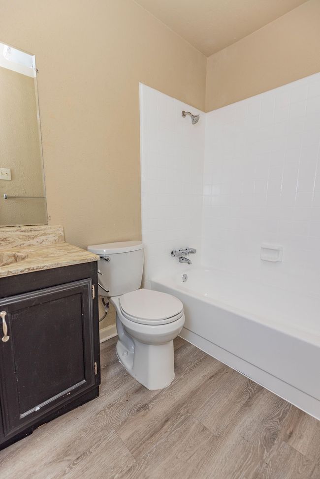 Full bathroom with vanity, hardwood / wood-style flooring, toilet, and shower combination | Image 11