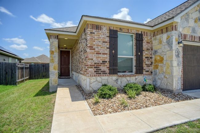 Property entrance featuring stone siding, a garage, and brick siding | Image 13