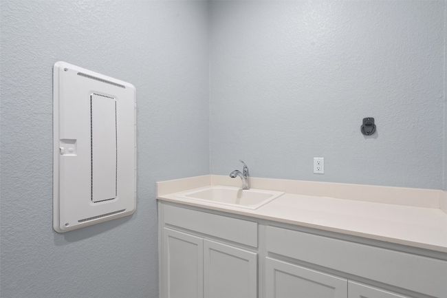Utility sink and additional folding and storage space found in the laundry room. | Image 26