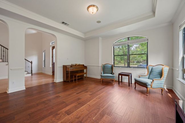 Sitting room with arched walkways, stairs, wood-type flooring, visible vents, and a raised ceiling | Image 18
