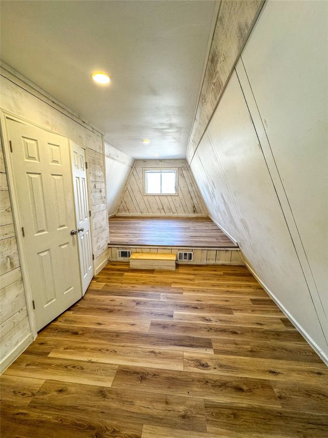 Bonus room with wooden walls, wood finished floors, and visible vents | Image 21