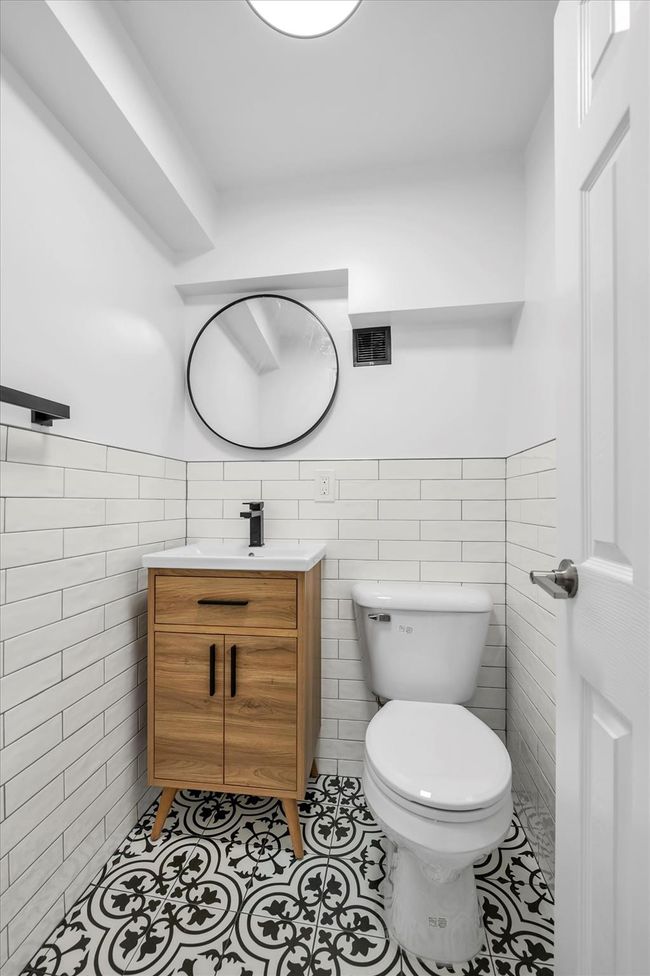 Bathroom featuring tile walls, vanity, tile patterned flooring, and wainscoting | Image 9