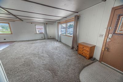 Carpeted bedroom with cooling unit, multiple windows, and a textured ceiling | Image 2