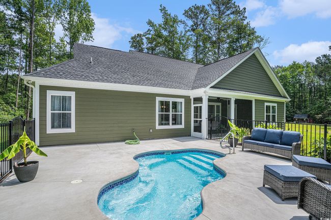 View of swimming pool with a patio area, outdoor lounge area, a sunroom, a ceiling fan, and fence | Image 32