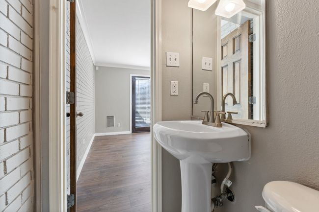 Bathroom with baseboards, crown molding, toilet, and wood finished floors | Image 13