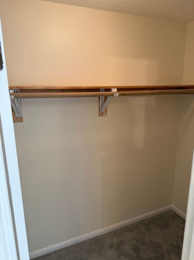 Spacious closet with dark carpet | Image 12