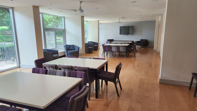 Clubroom featuring wood flooring and ceiling fans is available for hosting private and community events; includes kitchen & private patio. | Image 24