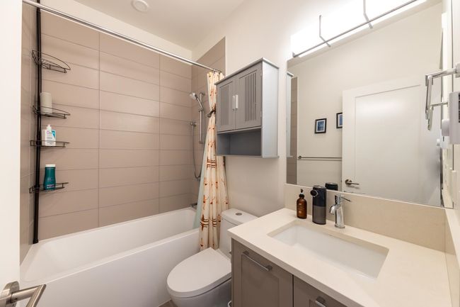 Bathroom with toilet, vanity, and shower / bath combination with curtain | Image 21